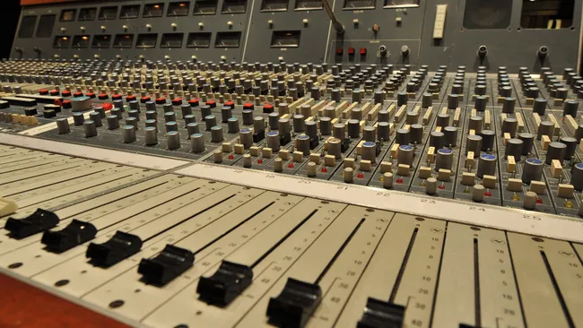 mixer audio con fader e manopole in uno studio di registrazione